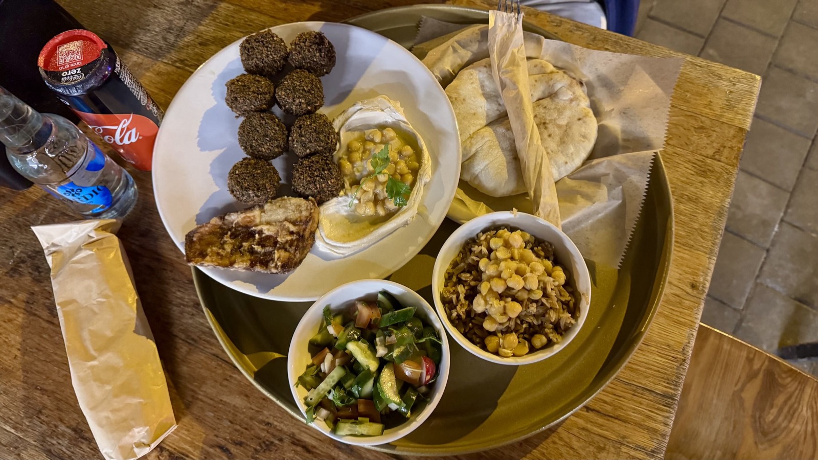 A falafel plate at HaKosem with hummus, pickles, salad and warm pita